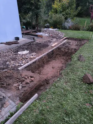 29. 9. 2025 — první výkop pro jezírko podél zdi domu.
